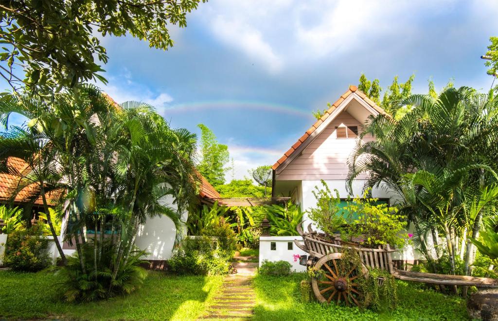 a house in the middle of a garden at E-outfitting Boutique Chiang Mai in Chiang Mai