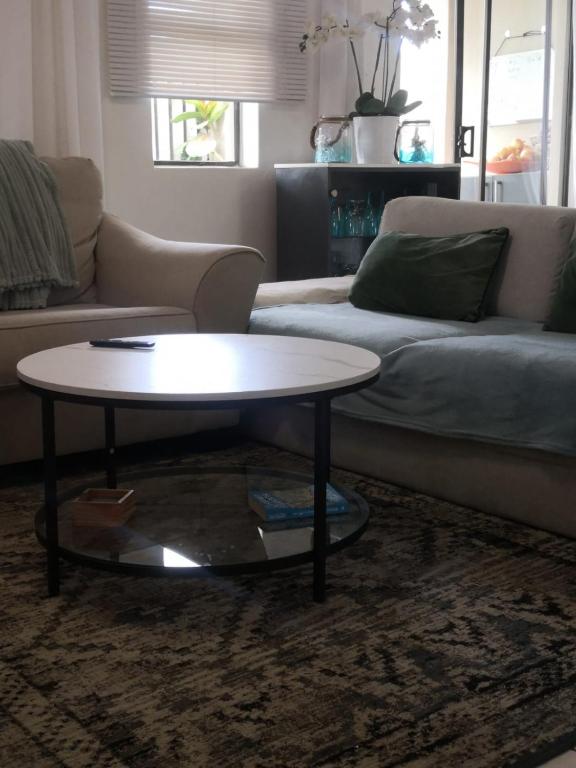 a living room with a coffee table and a couch at Duplex in Tableview in Cape Town