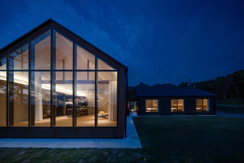 a house with large glass windows at night at 2R Yakushima in Yakushima