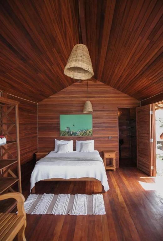 a bedroom with a bed and a wooden ceiling at Canto do Mar Caraiva in Caraíva