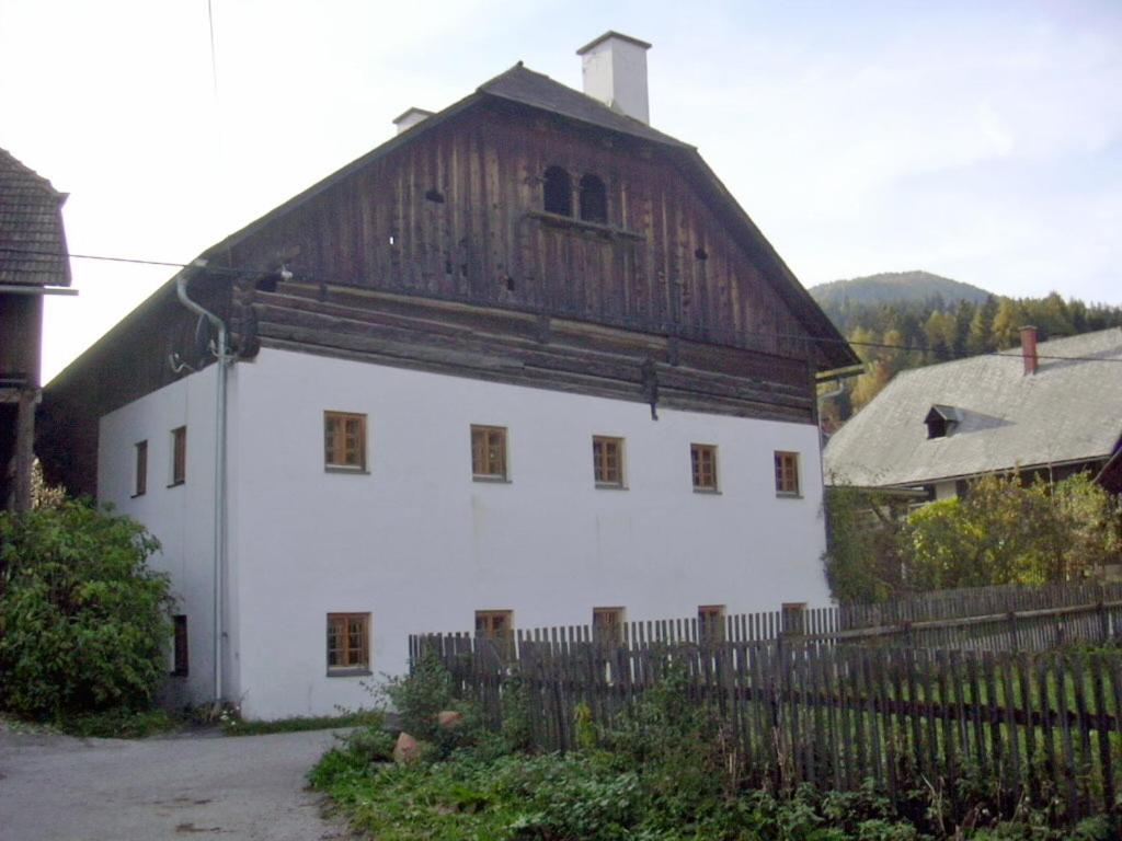 un grand bâtiment blanc avec un toit en bois dans l'établissement Bruggerhaus, à Schöder