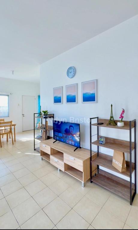 道伊斯Royal Palm 3的客厅里有书架，墙上挂着一台电视。