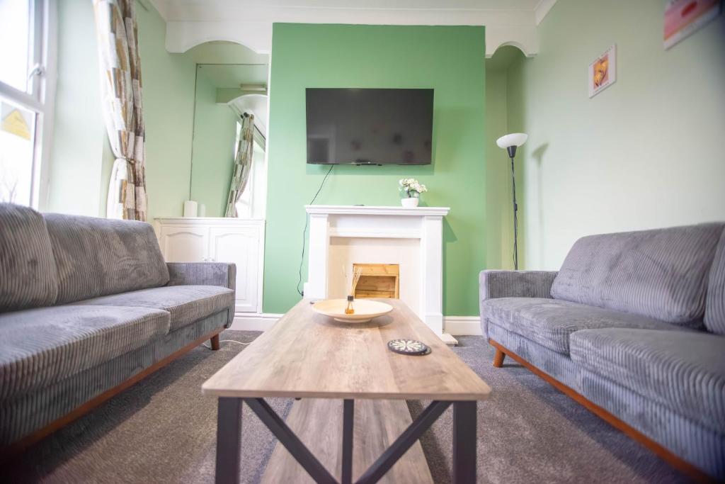 een woonkamer met twee banken en een open haard bij The Woodrouffee retreat in Carlisle