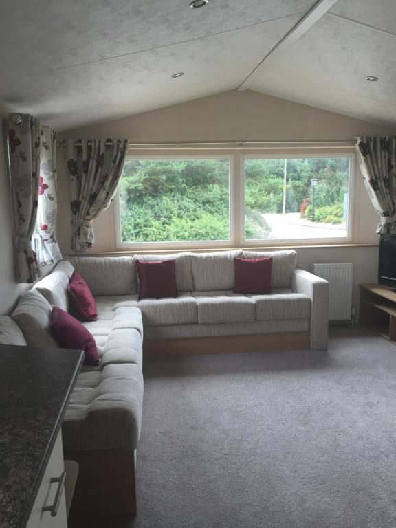 a living room with a couch and a large window at Lovely 3 Bed Caravan, Milford on Sea in Milford on Sea