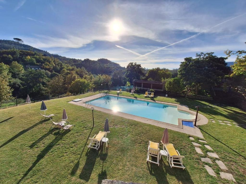 an aerial view of a swimming pool with chairs and umbrellas at Casa de Emaús - Gerês in Terras de Bouro