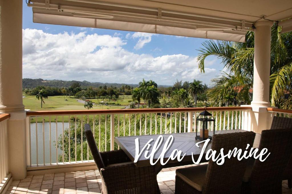 ein Balkon mit Tisch und Stühlen und Blick auf einen Golfplatz in der Unterkunft Villa Jasmine Ritz Reserve Plantation residence in Higuillar