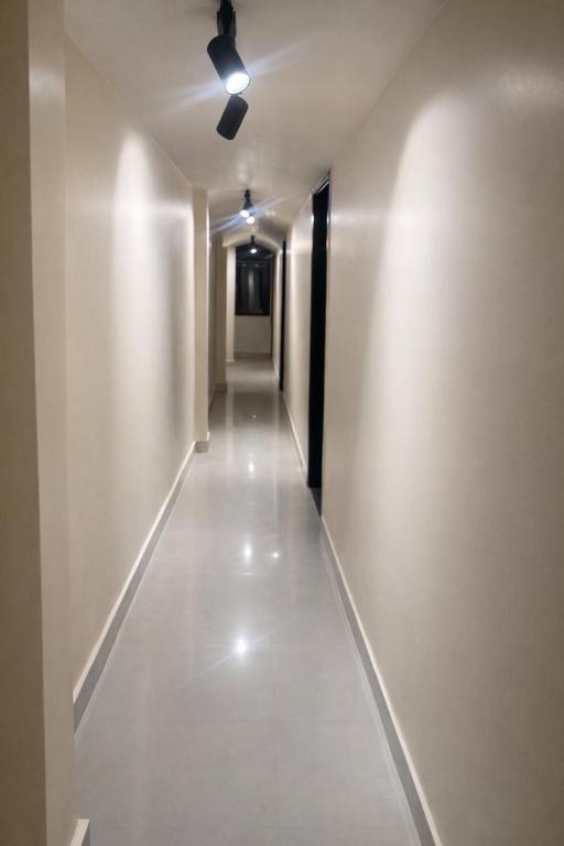 a long hallway with a ceiling fan in a building at Landmark Inn in Lanka