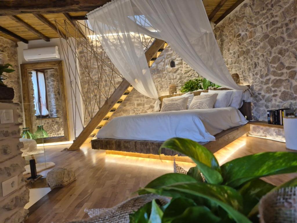 een slaapkamer met een bed in een stenen muur bij La Nuit d'Amélie 2 in Norma