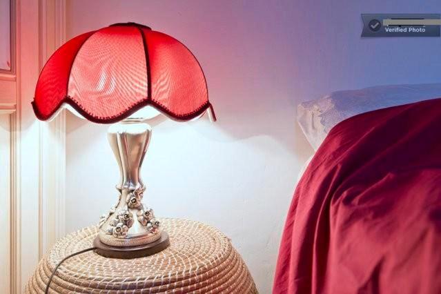 ローマにあるRomantic Ciclamini Houseのベッド横のテーブルに座る赤灯