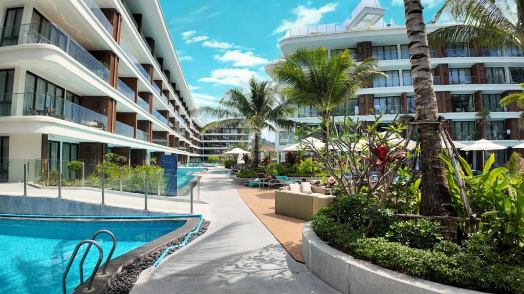 een resort met een zwembad en een gebouw bij Premier Kora 3-Bedroom Apartment E333 Beachfront in Layan Beach