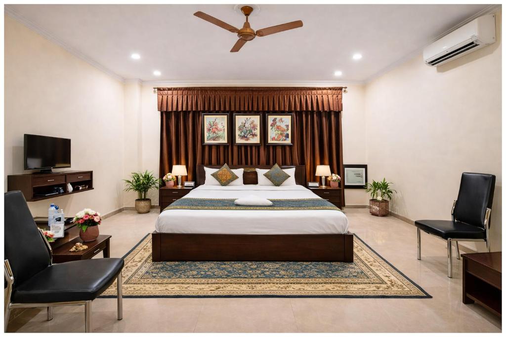een slaapkamer met een groot bed en twee stoelen bij Hotel A- Grand Residency Near Vishwanath temple - Free Wi-Fi & Restaurants - Air conditioning Room- Best Budget Hotel in Varanasi