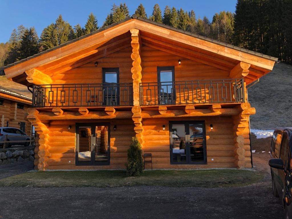 a log cabin with a balcony on top of it at Chalet Marmotte am Nassfeld in Hermagor