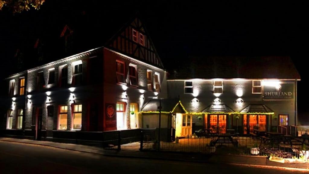 a building with lights on it at night at The Shurland Hotel in Eastchurch