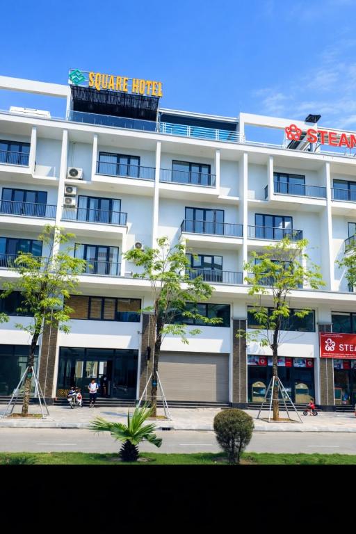 a white building with a sign on top of it at Square Hostel in Ha Long