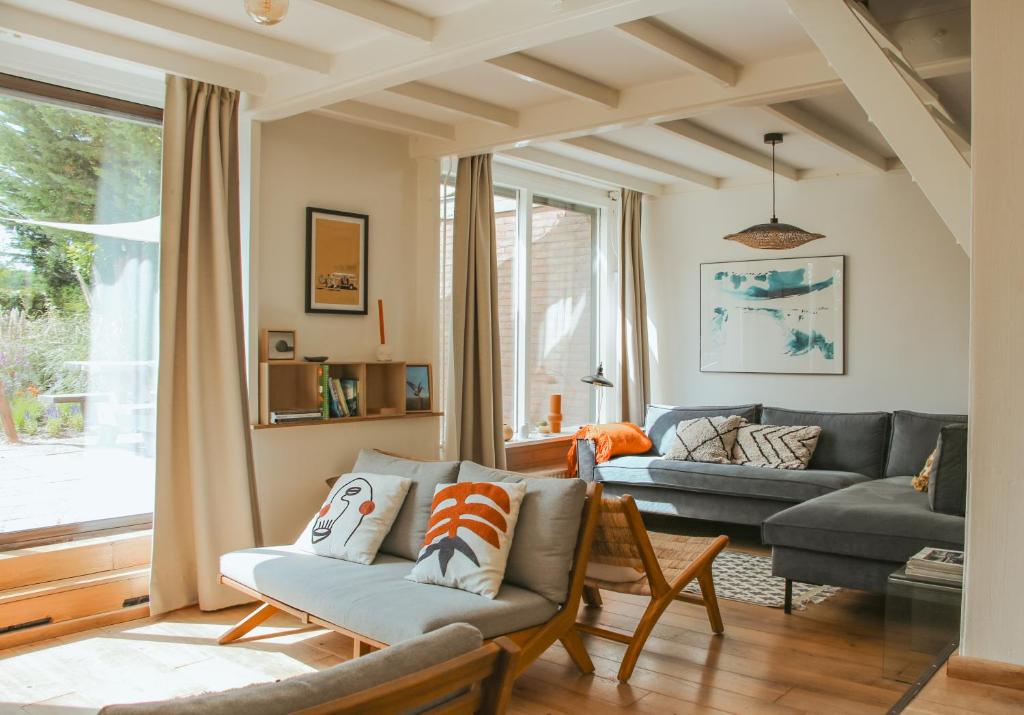 a living room with a couch and a table at Strandbries in Warmenhuizen