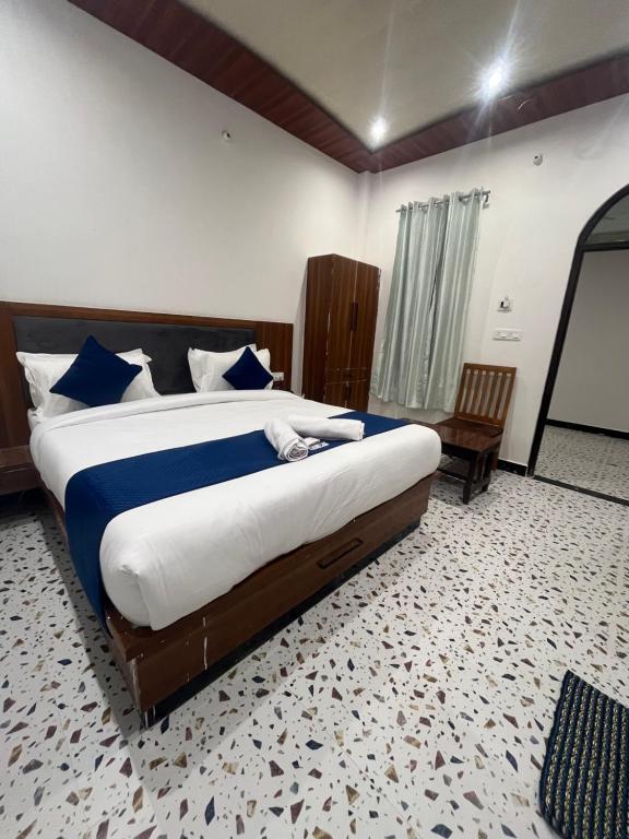 a bedroom with a large bed with blue and white sheets at The hotel Veshal In in Ayodhya