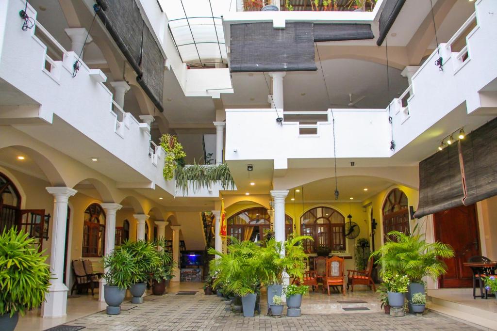 un hall d'un immeuble avec des plantes en pot dans l'établissement Angel Inn Guest House, à Negombo