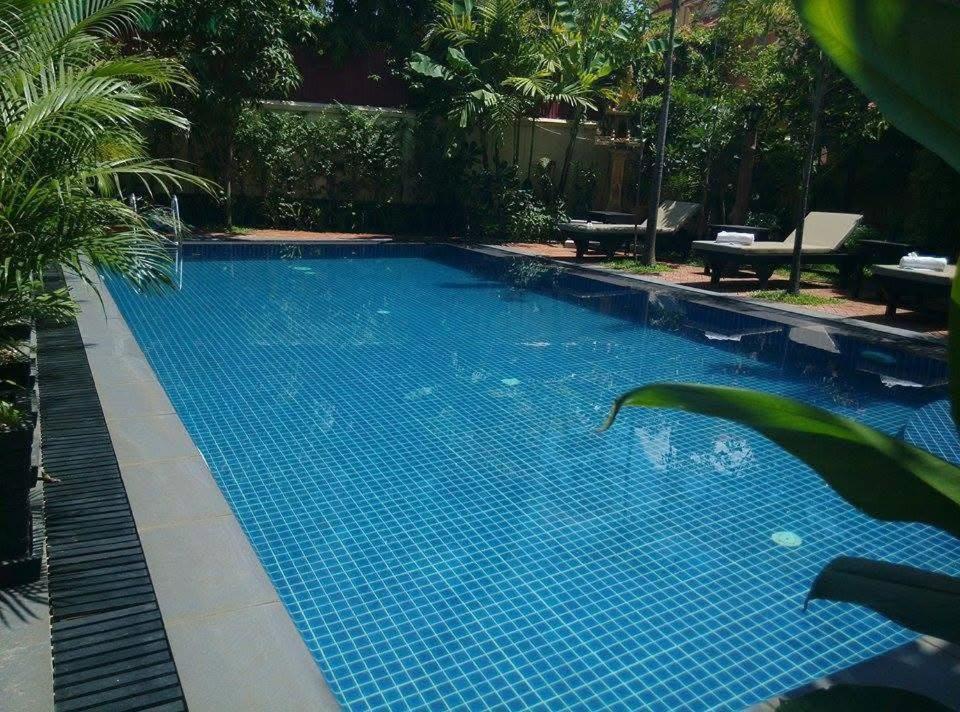 ein großes blaues Schwimmbecken mit blauen Fliesen in der Unterkunft Mony Soksan Residence in Siem Reap