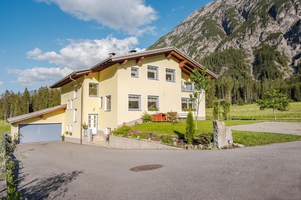 a house in front of a mountain at LechBrugger Berg Appartements in Holzgau