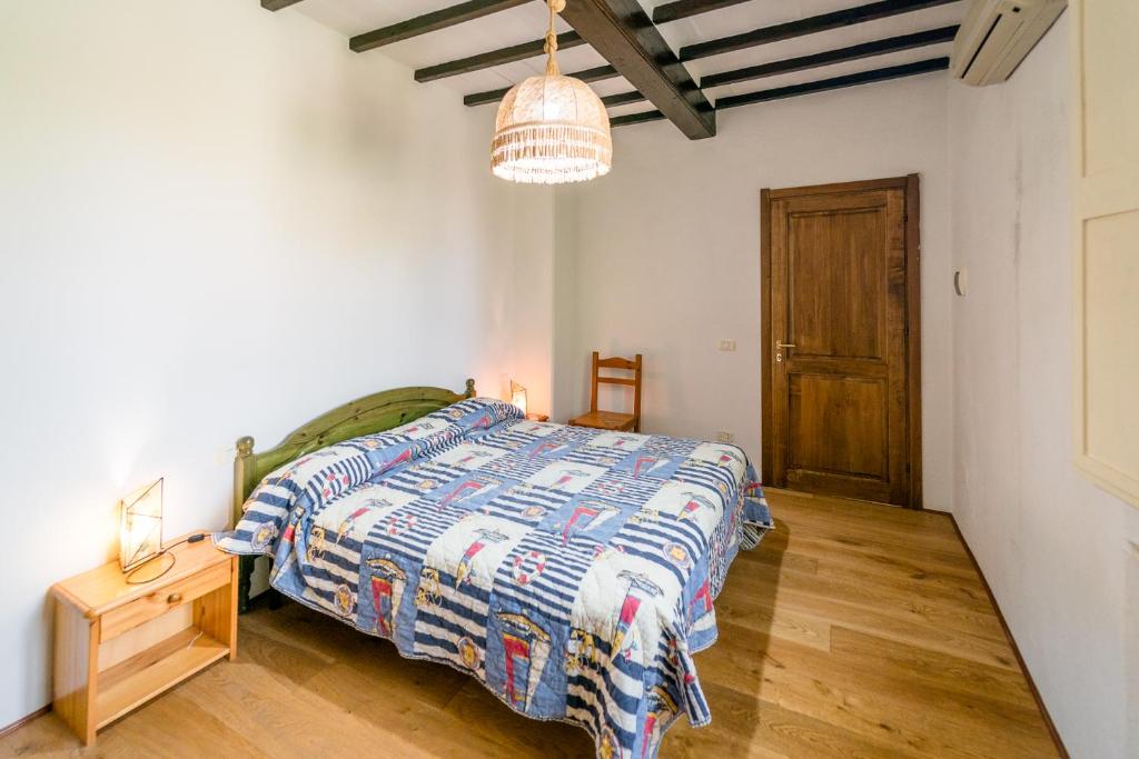 een slaapkamer met een bed en een houten vloer bij Hotiday Grosseto Podere in Vacchereccia