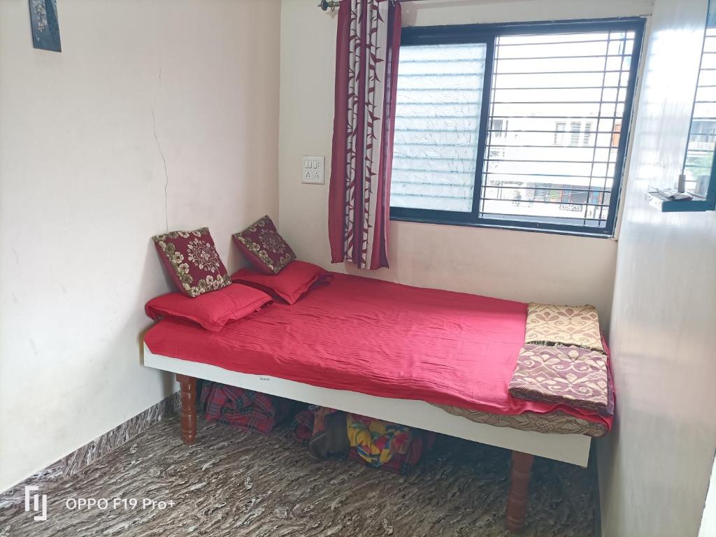 ein kleines Bett in einem Zimmer mit Fenster in der Unterkunft guest house Akshay in Akalkot