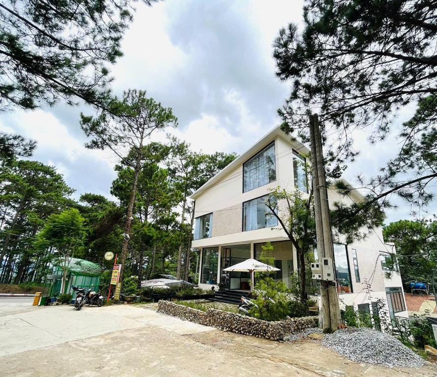a white house with trees in front of it at Tiên Hoa Sơn Villa in Da Lat