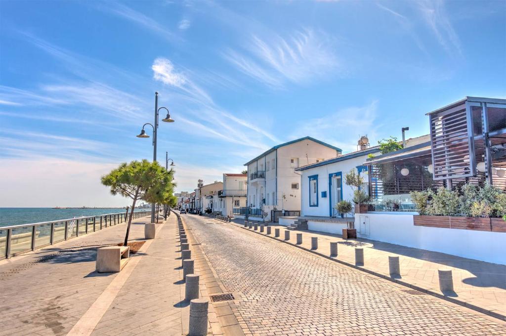 eine Straße neben dem Meer an einem Strand in der Unterkunft Nautica Luxe Heritage in Larnaka