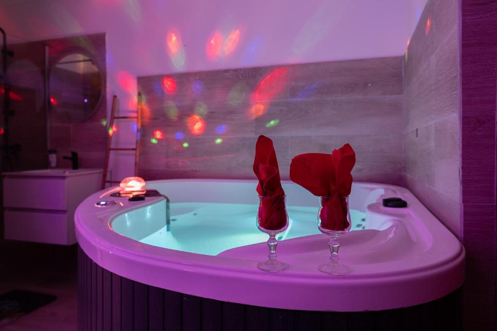 ル・ゴジエにあるLove Room Ô Fruit de la passionのバスルーム(バスタブ、ワイングラス2本付)