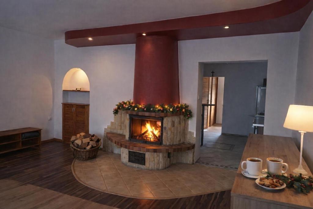 ein Wohnzimmer mit Kamin und Tisch in der Unterkunft Apartament z kominkiem in Jugów