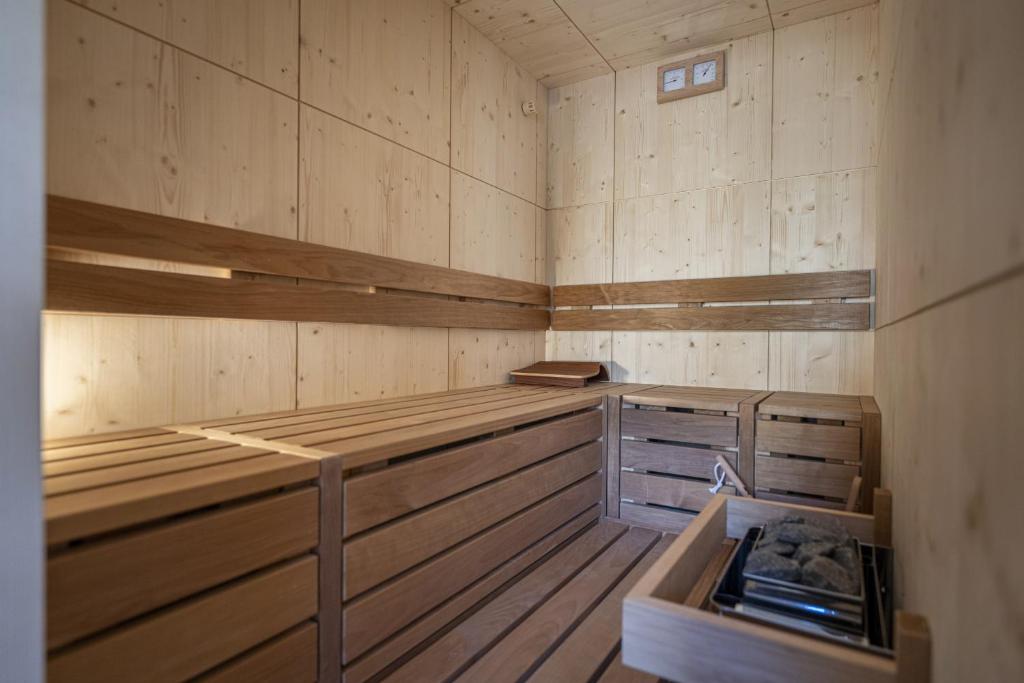 an empty sauna with wooden floors and wooden walls at Tieja Panoramic Lodge in Selva di Val Gardena