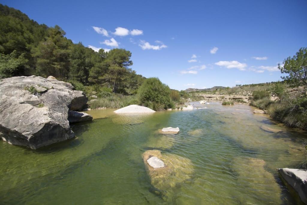 a river with rocks in the middle of it at La Quinta Terra Alta Matarraña in Caseras