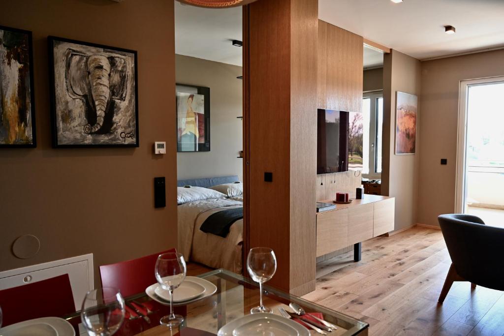 ein Zimmer mit einem Bett und einem Esstisch mit Weingläsern in der Unterkunft COme HOme Apartment in Bad Radkersburg