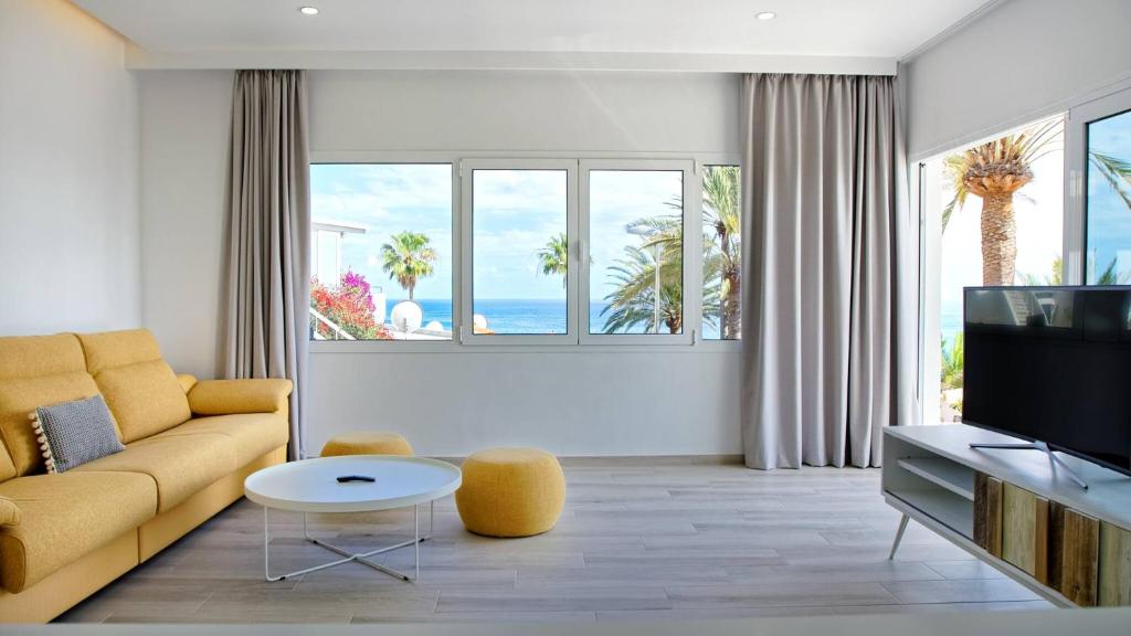 Una sala de estar con un sofá y un televisor. en Deva Beach Boutique Apartments, en San Fernando
