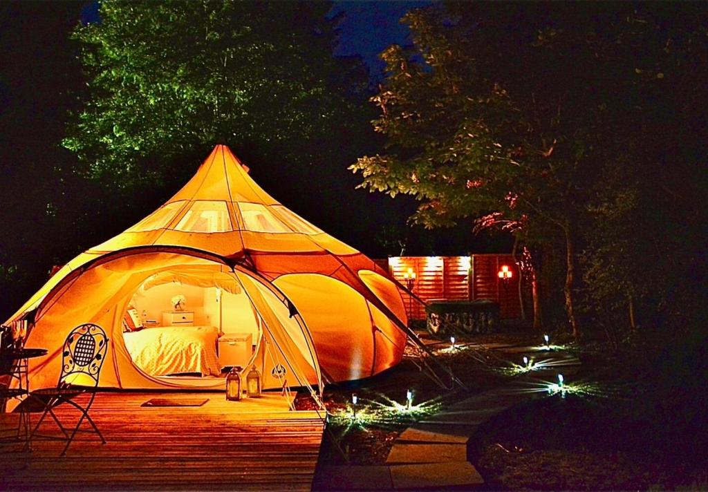 una grande tenda è illuminata di notte di Apple Blossom a Alkborough