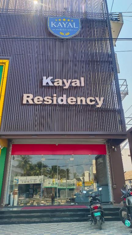 a kiwi restaurant with motorcycles parked in front of it at Kayalresidency in Gopichettipālaiyam
