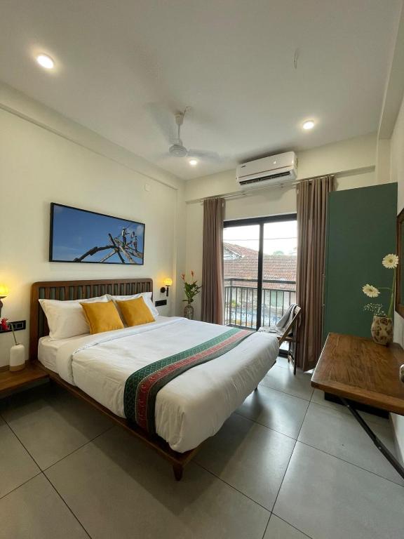 a bedroom with a large bed and a large window at Creek Harbour Fort Kochi in Fort Kochi