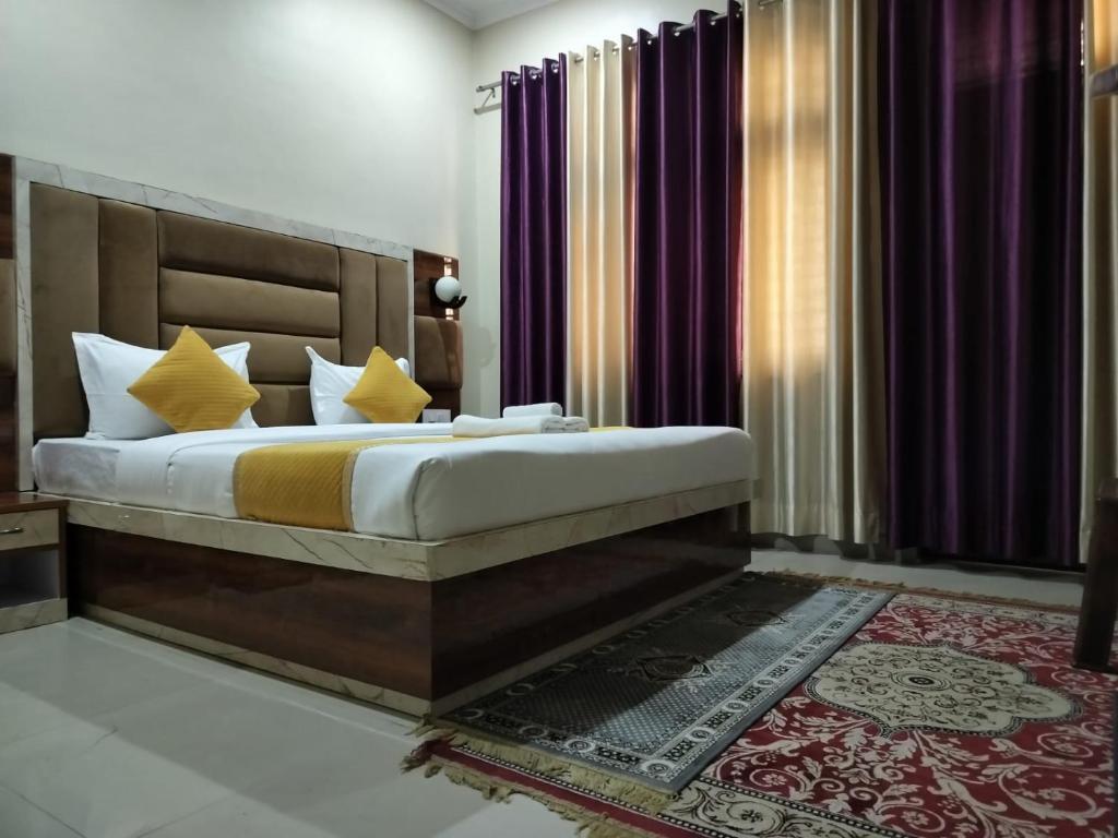 a bedroom with a large bed with yellow pillows at The Five D in Agra