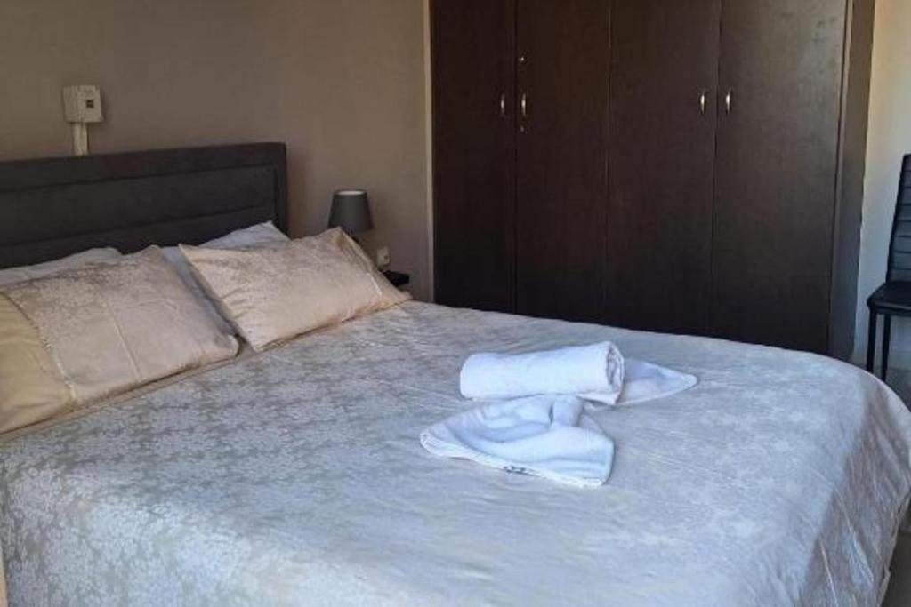 a bed with two towels sitting on top of it at 2br-7 Guests-Free Parking-Pool-AirCon in Paralimni