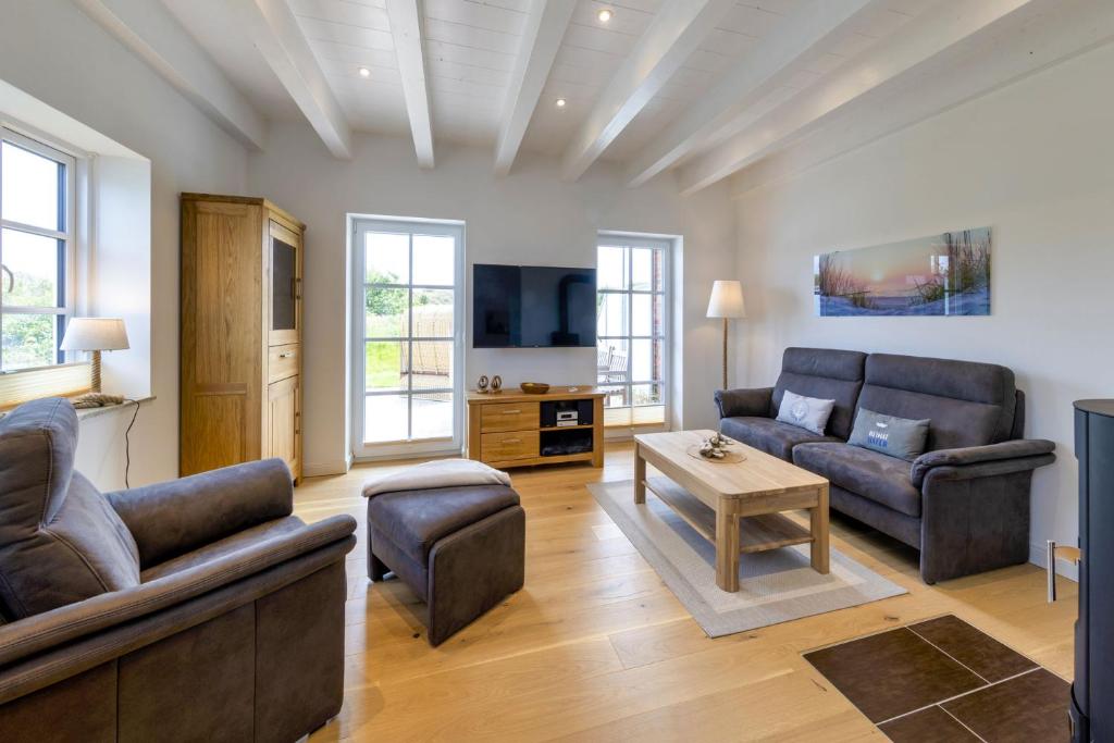 a living room with two couches and a tv at Haus Dünenperle, Ferienwohnung Dünengras in Wittdün