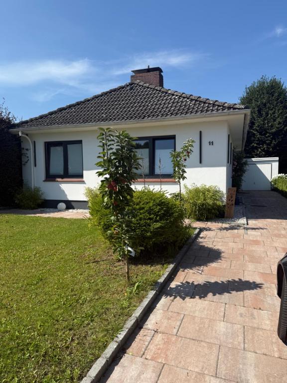 ein weißes Haus mit einem Baum im Hof in der Unterkunft Ferienhaus Kleiner Muck in Glückstadt