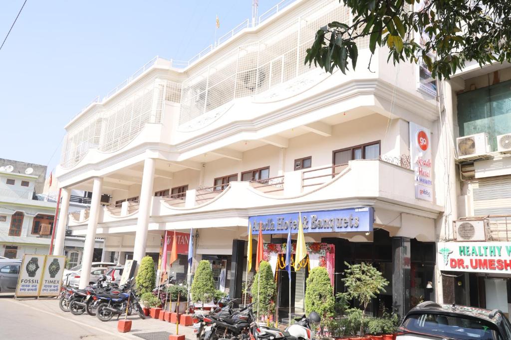 a white building with motorcycles parked in front of it at Avadh Hotel & Banquets in Bareilly
