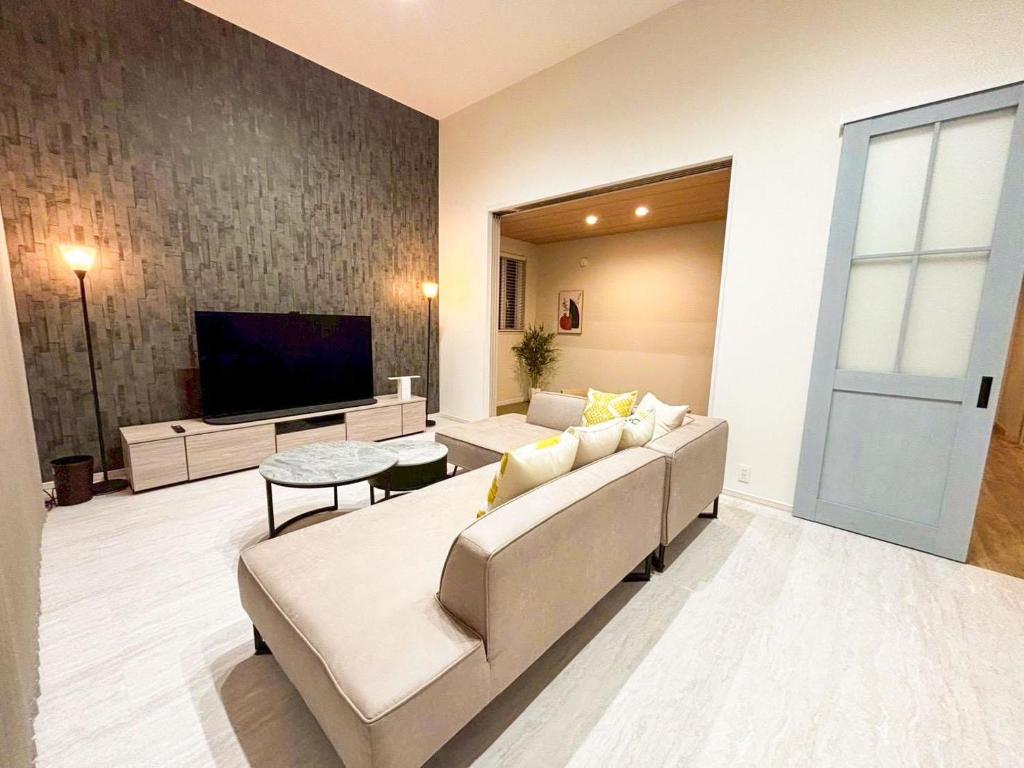 a living room with a couch and a flat screen tv at Cozy Stay Pippu in Tōma