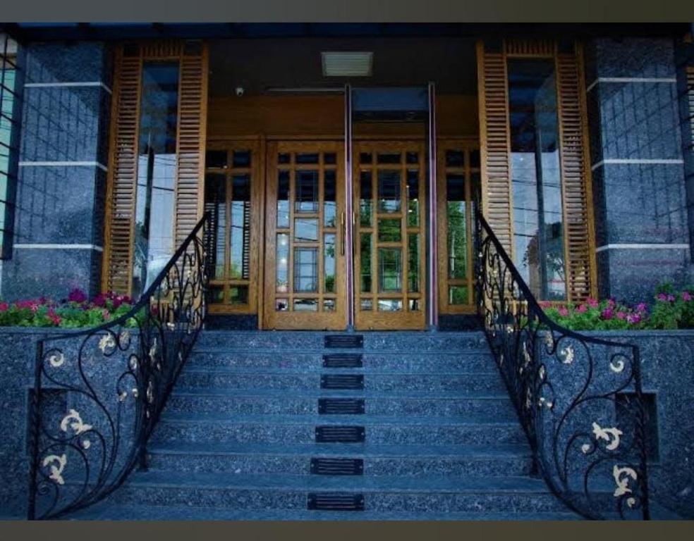 eine Treppe, die zu einem Haus mit Holztüren führt in der Unterkunft Heaven Hotel in Lahore