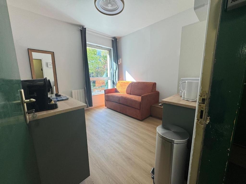 een woonkamer met een bank en een stoel bij New studio apartment hotel Palais des Congrès 11 in Levallois-Perret