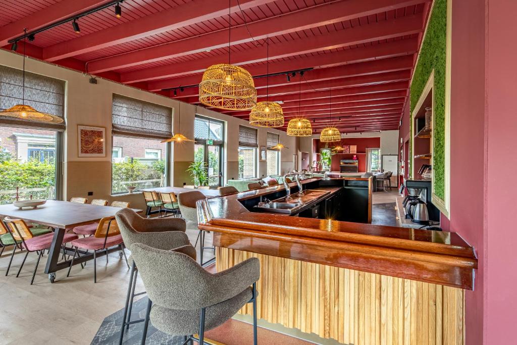 ein Restaurant mit Bar sowie Tischen und Stühlen in der Unterkunft Groepsaccommodatie De Landerij in Scherpenzeel
