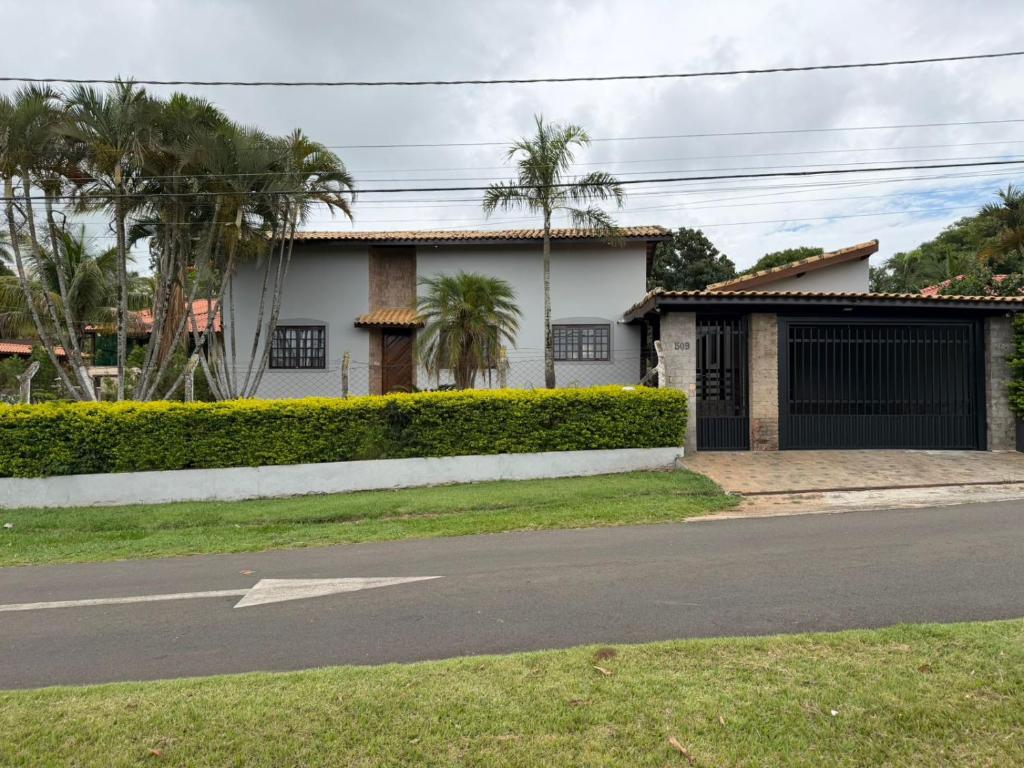 una casa bianca con palme di fronte a una strada di Carneiro a Boituva