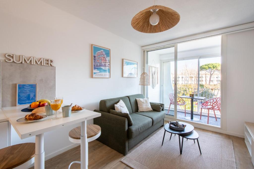 a living room with a couch and a table at Étoile de Mer * wifi * Parking * Clim * Central * in La Grande-Motte