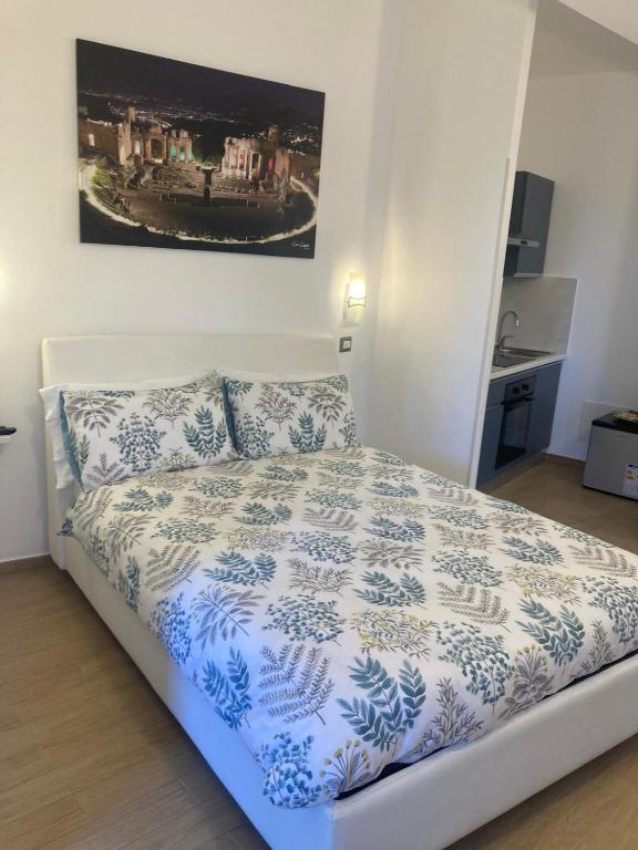a bedroom with a bed with a blue and white comforter at Elegant R&B Floridia in Taormina