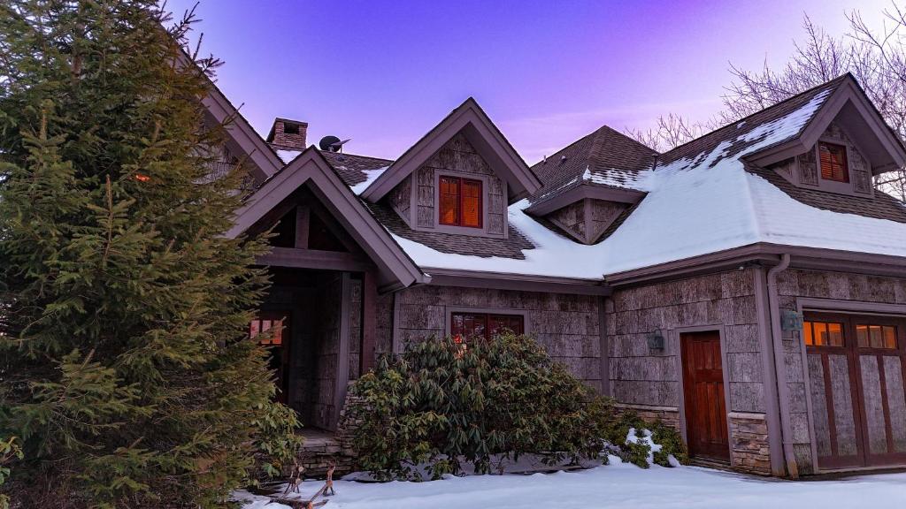 een huis met sneeuw op het dak bij Skytop Retreat in Sugar Mountain