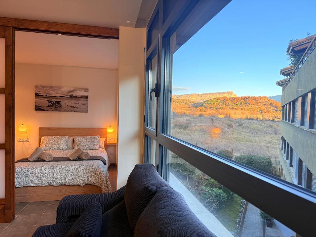 een slaapkamer met een bed en een groot raam bij El Loft de Salàs - L'Amfitriona in Salás de Pallás